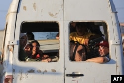 Palestinos desplazados junto a sus pertenencias viajan en una camioneta que circula por el campamento de Al-Bureij, en el centro de la Franja de Gaza, el 2 de junio de 2024. (Foto de Eyad BABA / AFP)