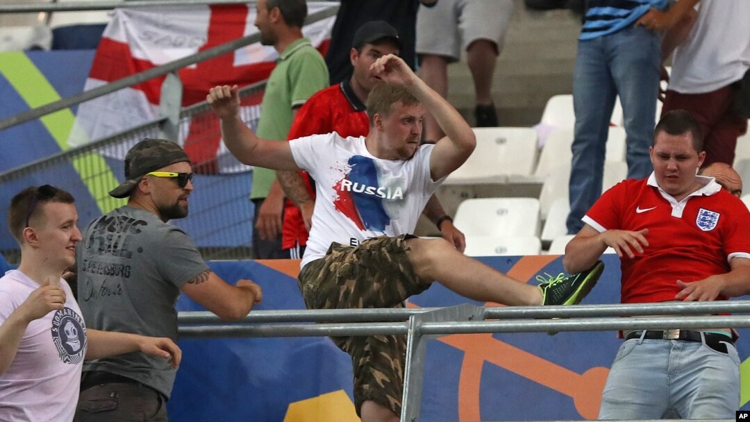 FILE - In this Saturday, June 11, 2016 file photo, Russian supporters attack an England fan at the end of the Euro 2016 Group B soccer match between England and Russia, at the Velodrome stadium in Marseille, France. 