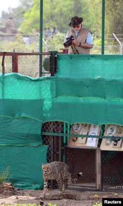 India's Prime Minister Narendra Modi holds a camera after he released cheetahs following their translocation from Namibia, in Kuno National Park, Madhya Pradesh, India, September 17, 2022. (India's Press Information Bureau/Handout via REUTERS)