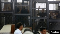 Muslim Brotherhood's General Guide Mohamed Badie (R) is pictured in a defendant's cage with other defendants in a courtroom in Cairo, June 7, 2014. 