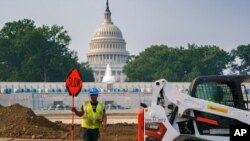 Trabajadores reparan un parque cerca del Capitolio en Washington, el 21 de julio de 2021, mientras los senadores luchan por llegar a un acuerdo sobre cómo pagar casi 1 billón de dólares en obras públicas.