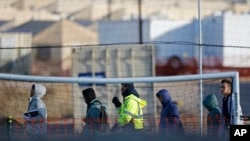 FILE - Teen migrants walk in line inside the Tornillo detention camp in Tornillo, Texas, Dec. 13, 2018.
