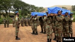 Des Casques bleus de la Mission des Nations unies au Mali, Minusma, portent les cercueils contenant les corps de deux de leurs collègues tués lors d'un attentat à Kidal, à Bamako, 18 décembre 2013. REUTERS/Adama Diarra