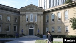 FILE - A student walks in front of the University of Toronto, St. George campus, in Toronto, Sept. 26, 2023.