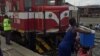 Uma mulher coloca uma mala na cabeça de outra na estação de Caminhos de Ferro de Moçambique, em Moatize