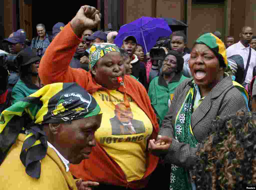 Members of the African National Congress Women's League sing in front of the courthouse ahead of the trial of Olympic and Paralympic track star Oscar Pistorius in Pretoria.