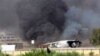 In this Saturday, July 26, 2014 frame grab from video obtained from a freelance journalist traveling with the Misarata brigade, shows an airplane on the tarmac of the airport belching black smoke into the air during fighting between the Islamist Misarata brigade and a powerful rival militia, in Tripoli, Libya. The battle for control of Tripoli's international airport began two weeks ago when Islamist-led militias - mostly from the western city of Misrata - launched a surprise assault on the airport, under control of rival militias from the western mountain town of Zintan. Heavy clashes in the country’s restive east between Libyan soldiers loyal to a renegade general and Islamist-led militias killed dozens of people including civilians, health officials said Sunday. On Saturday, the U.S. evacuated its diplomats in Tripoli to neighboring Tunisia and shut its embassy. (AP Photo/AP video)