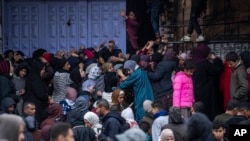 Palestinos tratan de comprar pan en una panadería en Rafah, en la Franja de Gaza, el domingo 18 de febrero de 2024. Agencias internacionales de ayuda dicen que Gaza sufre desabastecimiento de comida, medicamentos y otros suministros básicos.