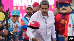 El presidente venezolano Nicolás Maduro lanza una gorra durante un acto de campaña política para la votación del 28 de este mes, en Caracas, el 8 de julio.