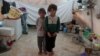 Des frères et sœurs syriens, déplacés de l'est de la province d'Idlib, posent pour une photo dans une tente du camp d'Atmeh en Syrie, près de la frontière turque, le 19 juin 2020.
