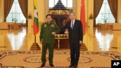 El jefe militar de Birmania, y ahora líder del país, el general Min Aung Hlaing, a la izquierda, y el ministro de Exteriores chino Wang Yi, posan para una foto durante su reunión el 12 de enero de 2021.
