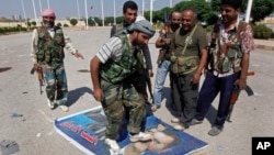 Seorang anggota Laskar Pembebasan Suriah (FSA) menginjak gambar Presiden Bashar al-Assad di kota Tal Abyad dekat perbatasan Turki (foto: dok). 