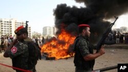 Hamas security forces stand guard while they burn some 1,383 bars of hashish and 1,242,000 pills of Tramadol, that have been seized since the beginning of the year, before they burn it, in Gaza City, Monday, Oct. 22, 2018. 