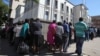 Residents queue to withdraw cash at a local bank in Harare, Zimbabwe, May 5, 2016.