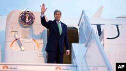 FILE - Secretary of State John Kerry waves as he boards his plane at Orly Airport, south of Paris, France, en route to Vienna, Austria, Oct. 15, 2014. 
