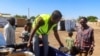 Um voluntário de uma cozinha móvel sudanesa serve uma refeição a uma criança deslocada do estado de Gezira devido à violência das Forças de Apoio Rápido (RSF), num dos centros de deslocação em New Halfa