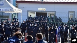 Riot police officers stand at the entrance of a courthouse during the trial of 475 defendants, including generals and fighter jet pilots, in Sincan, Ankara, Turkey, Nov. 26, 2020.