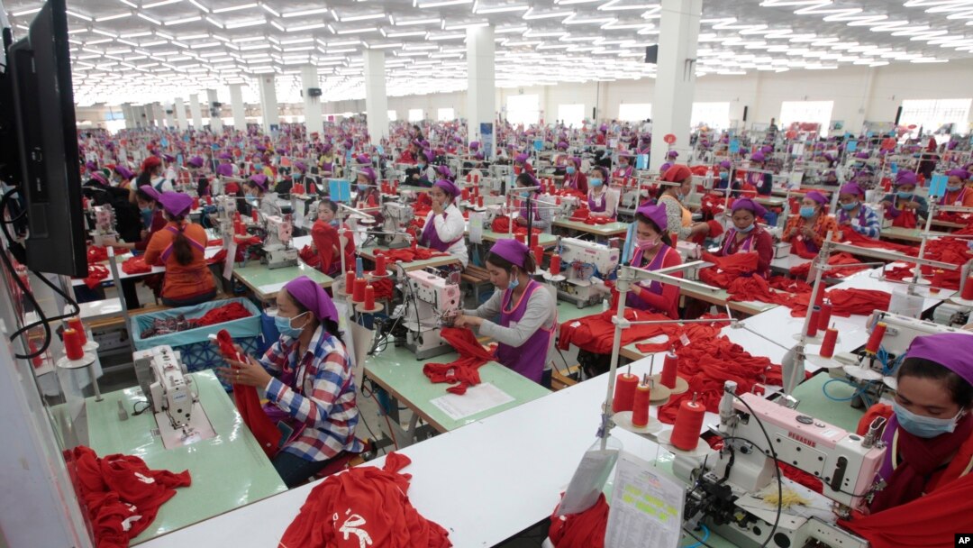 FILE - Garment workers sew clothes in a factory outside Phnom Penh, Cambodia, Aug. 30, 2017. A new government initiative now makes available to them free legal services to help settle disputes with employers. But some see the offer as hollow.