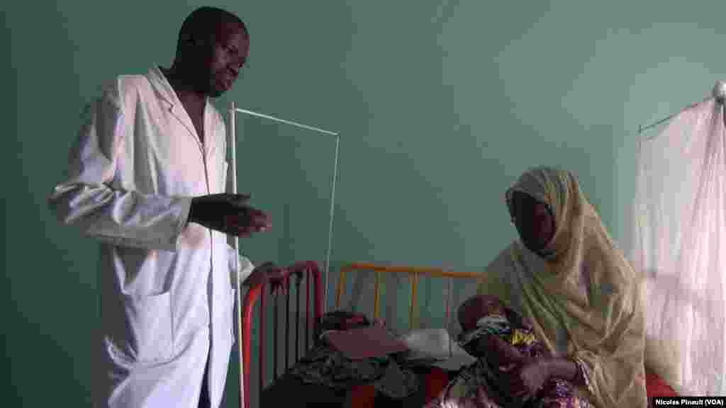 Le docteur Moustapha Saley s'entretient avec la mère d'un enfant souffrant de malnutrition aiguë au centre régional de santé mère enfant de Diffa, Niger, le 18 avril 2017 (VOA/Nicolas Pinault)