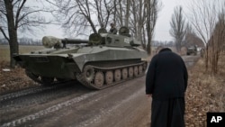 Seorang pendeta memberi hormat kepada para pejuang separatis pro-Rusia berkendaraan lapis baja di Yelenovka, dekat Donetsk, Ukraine (27/2)