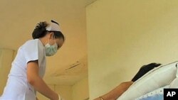 A nurse preps an HIV-infected patient in Bangkon, Thailand, for a round of anti-retroviral drugs to treat the condition, 29 Nov 2010