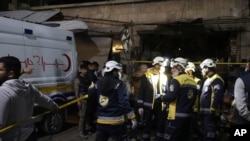 Trabajadores de los Cascos Blancos buscan víctimas tras la explosión de un coche bomba en un bullicioso mercado el domingo 31 de marzo de 2024 en la madrugada, en Azaz, Siria, una ciudad noroccidental controlada por Turquía. [Cascos Blancos/Defensa Civil Siria vía AP]