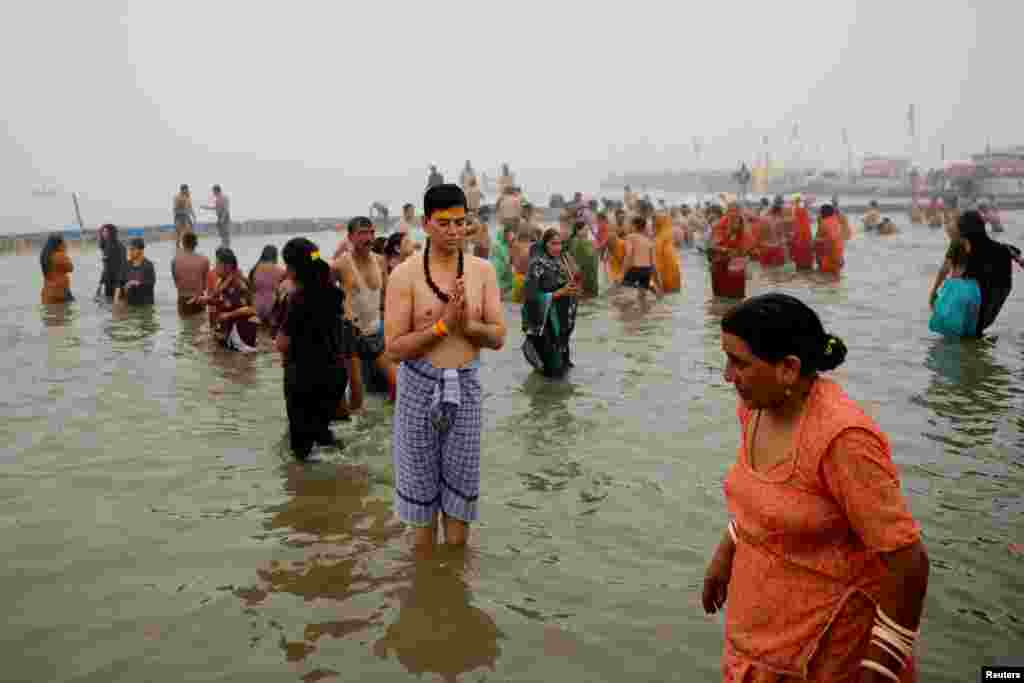 A devotee prays as he takes a holy dip at Sangam, the confluence of the Ganges, Yamuna and Saraswati rivers, during the "Maha Kumbh Mela", or the Great Pitcher Festival, in Prayagraj, India, Jan. 13, 2025.