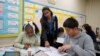 Seorang tutor membimbing para siswa dalam kegiatan belajar mengajar di Benjamin O. Davis Middle School di Compton, California, pada 6 Februari 2025. (Foto: AP/Eric Thayer)