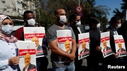 FILE - People hold pictures of Saudi journalist Jamal Khashoggi during a gathering to mark the second anniversary of his killing at the Saudi Consulate, in Istanbul, Turkey, Oct. 2, 2020. 