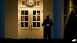 Un oficial de la Marina vigila la entrada al Ala Oeste de la Casa Blanca, después que se decidiera que el presidente Donald Trump será enjuiciado nuevamente. La presencia del soldado significa que el presidente está en la Oficina Oval.