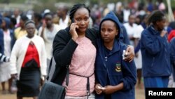 Orang tua siswa merangkul putrinya setelah insiden kebakaran yang membakar satu asrama di Sekolah Tinggi Moi Girls di Nairobi, Kenya, 2 September 2017. (REUTERS/Baz Ratner).