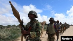 FILE - African Union Mission in Somalia (AMISOM) peacekeepers from Burundi patrol after fighting between insurgents and government soldiers on the outskirts of Mogadishu, May 22, 2012.