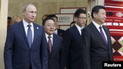 (L-R) Russian President Vladimir Putin, Mongolian President Tsakhia Elbegdorj and Chinese President Xi Jinping arrive for a meeting during the BRICS Summit in Ufa, Russia, July 9, 2015.
