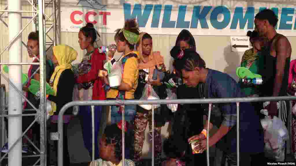 Des migrants attendent de se faire enregistrer par les autorités italiennes, Catane, Sicile, 6 octobre 2015 (Nicolas Pinault/VOA). 