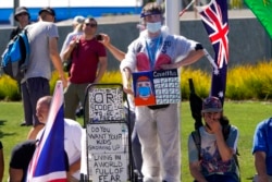Demonstran anti-vaksinasi berdemonstrasi di luar Melbourne Park setelah Novak Djokovic diyakini ditahan di sebuah hotel detensi imigrasi di Melbourne, Australia, 15 Januari 2022. (Foto: AP)
