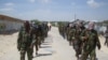 FILE - Members of Somalia's al-Shabab militant group patrol on the outskirts of Mogadishu, March, 5, 2012. 