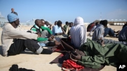 Migran Afrika beristirahat setelah diselamatkan oleo Penjaga Pantai Libya di sebelah barat Tripoli, 21 Desember 2015.