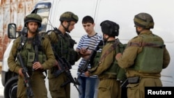 Tentara Israel mencari seorang remaja Palestina dalam operasi untuk mencari tiga remaja Israel yang diculik, di Hebron, Tepi Barat (16/6). 