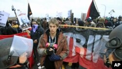 A protester faces a line of riot police during the Occupy movements' attempt to shut down west coast ports in Long Beach, California, December 12, 2011.