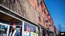 U.S. flags hang outside a downtown building whose storefronts are made up of businesses started by African immigrants who have settled in Lewiston, Maine, March 17, 2017. Maine's immigrants from Sub-Saharan Africa made $136.6 million in income in 2014, and paid $40 million in taxes, according to a report from the New American Economy. 