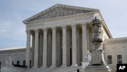 People walk outside the Supreme Court in Washington, March 16, 2020.