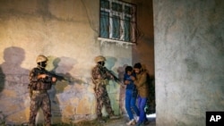 Turkish security forces apprehend a group of migrants in an operation aimed at stemming the recent influx of migration, mainly coming from Afghanistan, in the area at the border province of Van, Turkey, Aug. 21, 2021.