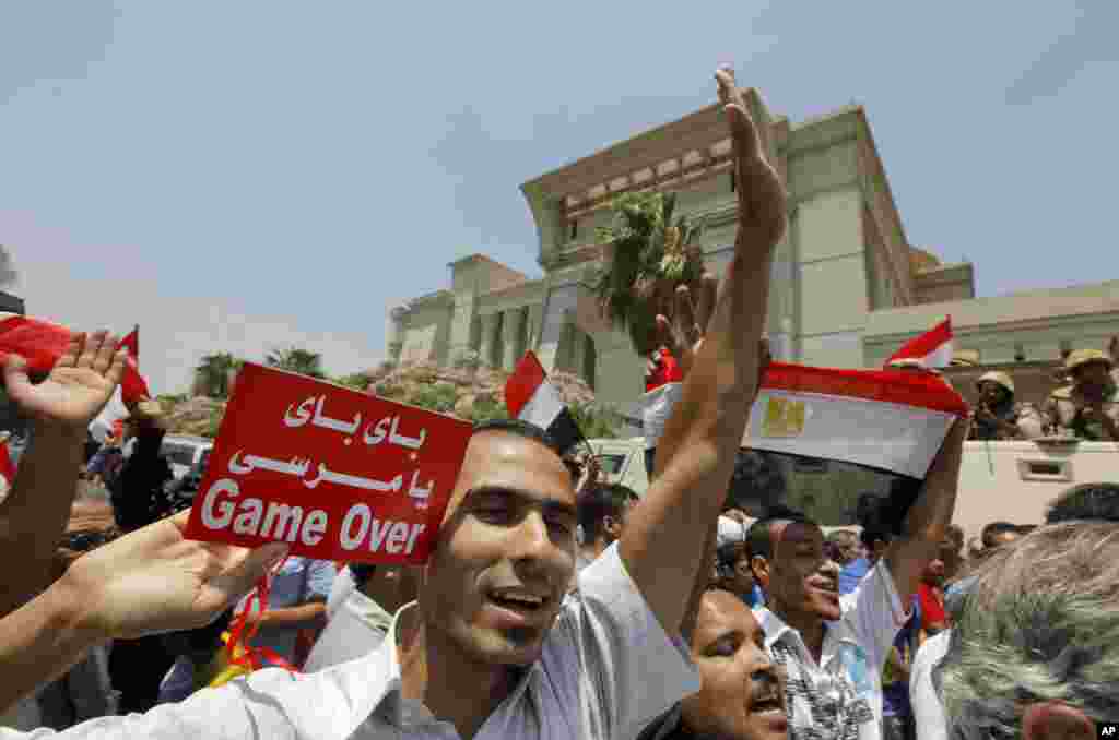 Egyptians celebrate after Egypt's chief justice Adly Mansour is sworn in as the nation's interim president, July 4, 2013. Arabic reads, " bye bye Morsi."
