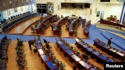 Empleados del Congreso organizan la sala tras la sesión especial de aprobación de la licencia del presidente Nayib Bukele, solicitada por el mandatario para ocuparse de la campaña de reelección de 2024, en San Salvador, el 30 de noviembre de 2023.