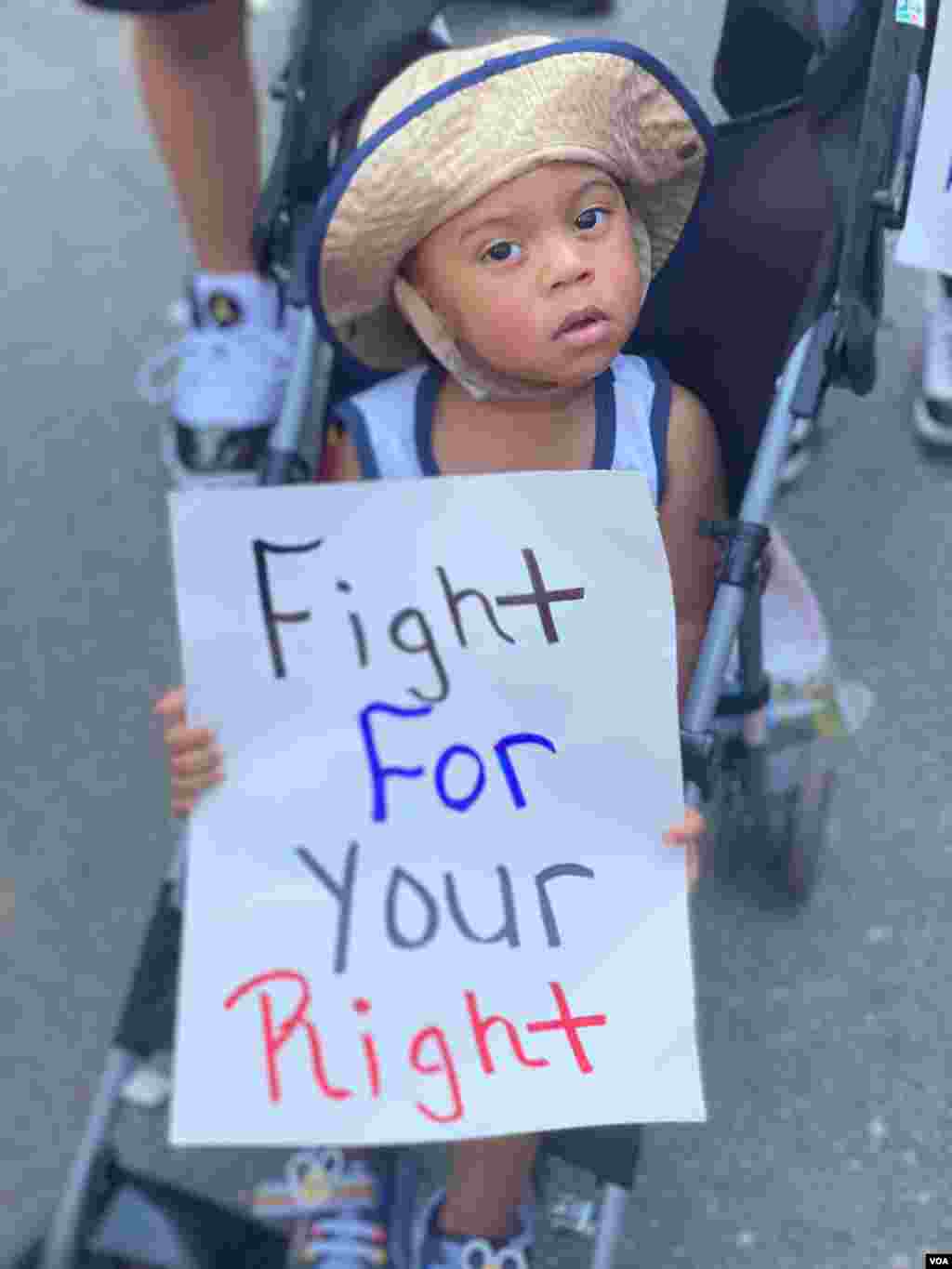 Un niño en las protestas de Washington D.C. sujeta un cartel que dice "Lucha por tus derechos". Sábado 20 de junio de 2020