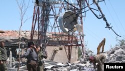 Pejuang dari Kelompok Perlindungan Warga Kurdi (YPG) memeriksa kerusakan markas besar mereka pasca serangan udara pesawat Turki di Mount Karachok dekat Malikiya, Suriah, 25 April 2017. (REUTERS/ Rodi Said).