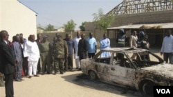 Warga Nigeria mengelilingi sebuah mobil yang terbakar akibat pemboman yang memicu bentrokan antarkelompok bersenjata Kristen dan Muslim.