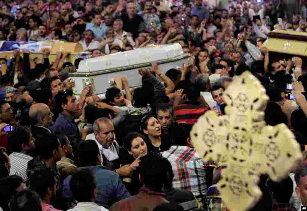 Egyptian Christians carry four coffins during a funeral service, at the Saint Mark Coptic cathedral in Cairo, Egypt, April 7, 2013.