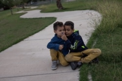 Dos niños hondureños de 5 y 9 años esperan para ser transportados a un centro de procesamiento en EE. UU. después de cruzar el río Grande desde México en una balsa en La Joya, Texas, el 5 de mayo de 2021.