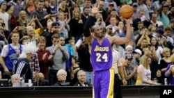Los Angeles Lakers guard Kobe Bryant (24) holds up the game ball and acknowledges the crowd during an NBA basketball game against the Minnesota Timberwolves after passing Michael Jordan on the NBA all-time scoring list, in Minneapolis, Dec. 14, 2014.